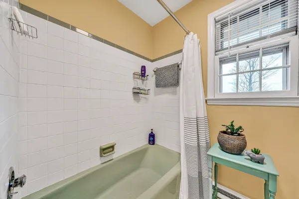 a bathroom with a tub sink and mirror