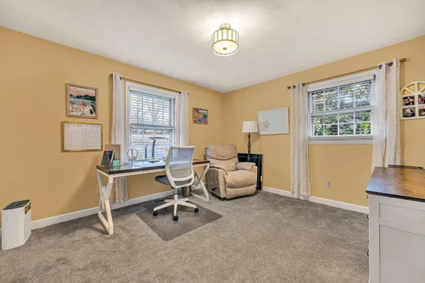 a view of a livingroom with workspace and a window