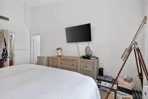 a bedroom with a bed and a potted plant