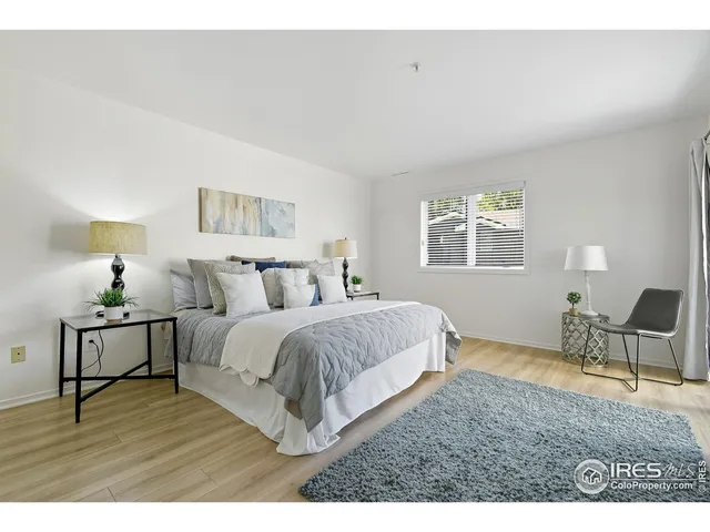 a spacious bedroom with a bed a table and chair