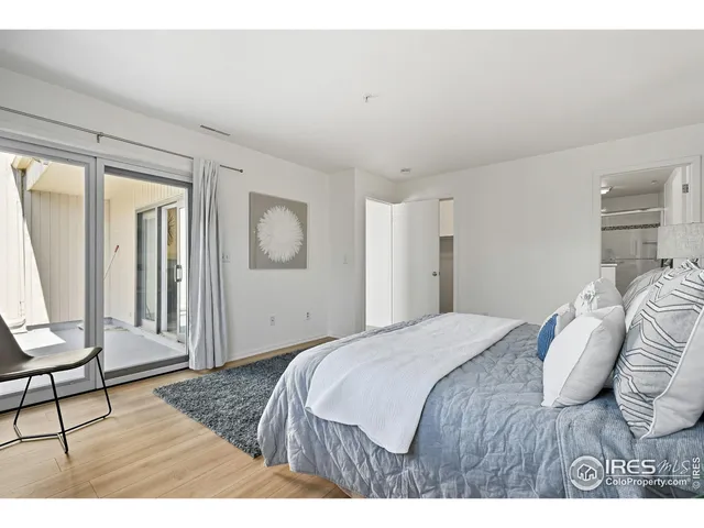 a bedroom with a bed a chair and next to a window