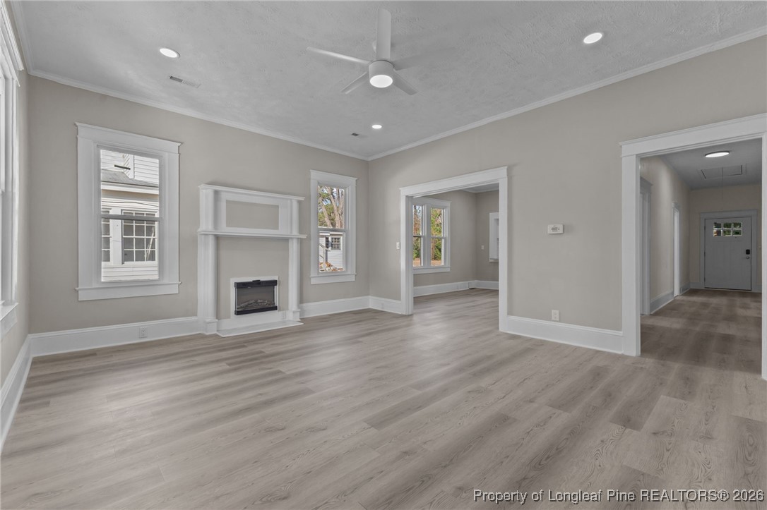 220 Beaman Street Clinton, NC 28328 - Photo 5 of 32 an empty room with wooden floor and windows