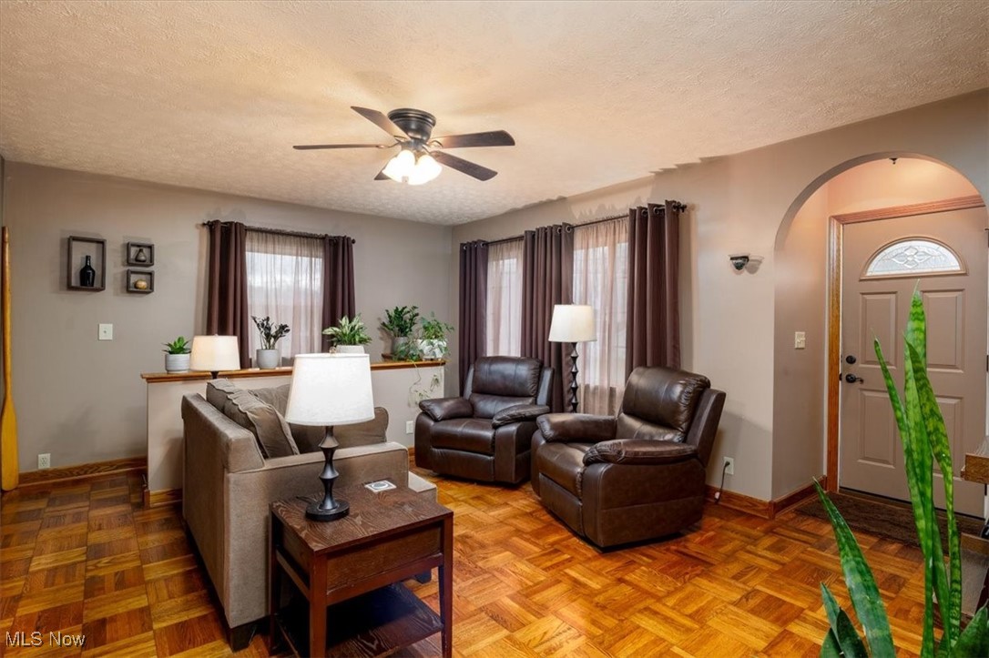 3831 Cook Road Rootstown, OH 44272 - Photo 9 of 25 Living room with beautiful parquet floor, windows, and ceiling fan