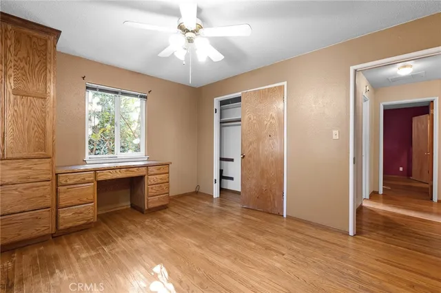 an empty room with a ceiling fan and window