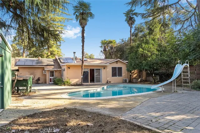 a kitchen with a sink a refrigerator a stove and white cabinets with wooden floor