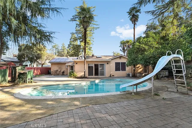 an empty room with a window and a chandelier fan