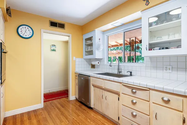 a kitchen with granite countertop a sink and a wooden floor