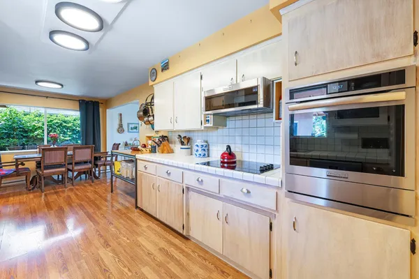 a kitchen with stainless steel appliances a stove a sink a microwave and cabinets