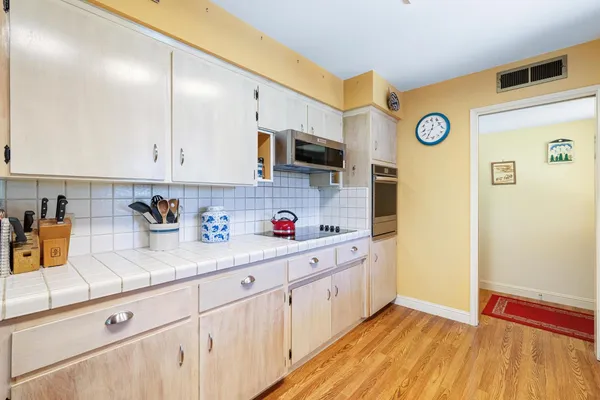 a kitchen with cabinets and wooden floor