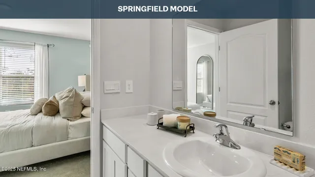 a en suite bathroom with a double vanity sink and mirror