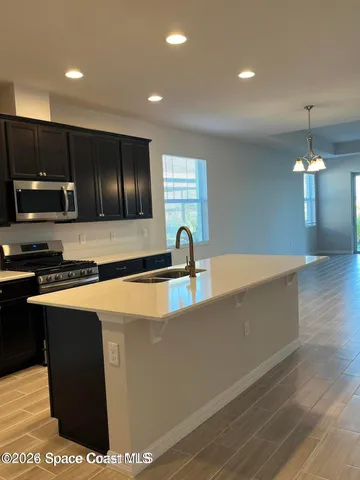 a kitchen with stainless steel appliances granite countertop a sink a stove and a refrigerator