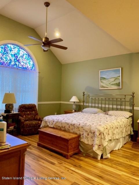 26 Tides Lane Staten Island, NY 10309 - Photo 20 of 41 a bedroom with a bed and wooden floor