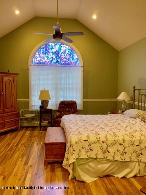 26 Tides Lane Staten Island, NY 10309 - Photo 25 of 41 a bedroom with a bed and wooden floor
