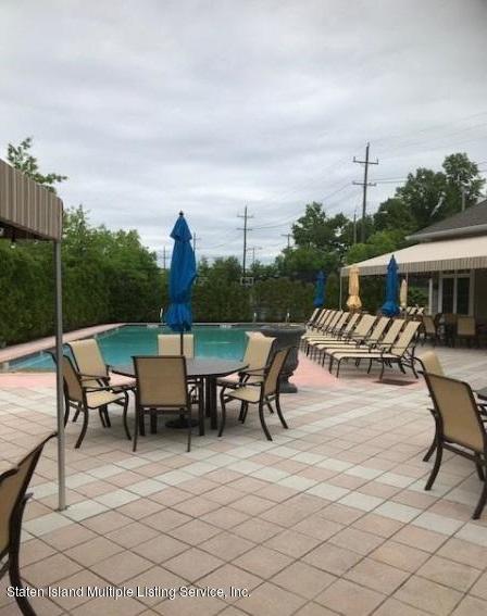 26 Tides Lane Staten Island, NY 10309 - Photo 35 of 41 a view of a patio with dining table and chairs with a fire pit