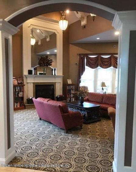 26 Tides Lane Staten Island, NY 10309 - Photo 36 of 41 a living room with furniture a large window and a fireplace