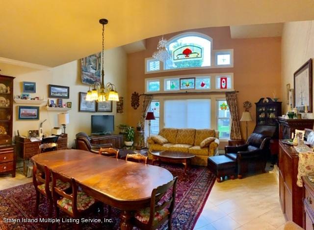 26 Tides Lane Staten Island, NY 10309 - Photo 5 of 41 a living room with furniture a fireplace and many windows