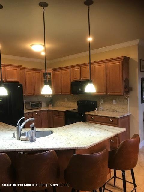 26 Tides Lane Staten Island, NY 10309 - Photo 8 of 41 a kitchen with kitchen island granite countertop a sink a counter top space appliances and cabinets
