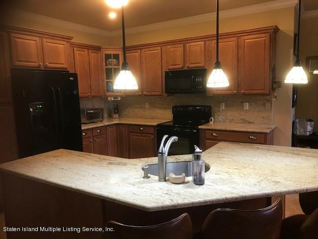 26 Tides Lane Staten Island, NY 10309 - Photo 9 of 41 a kitchen with kitchen island granite countertop a sink a counter top space and cabinets