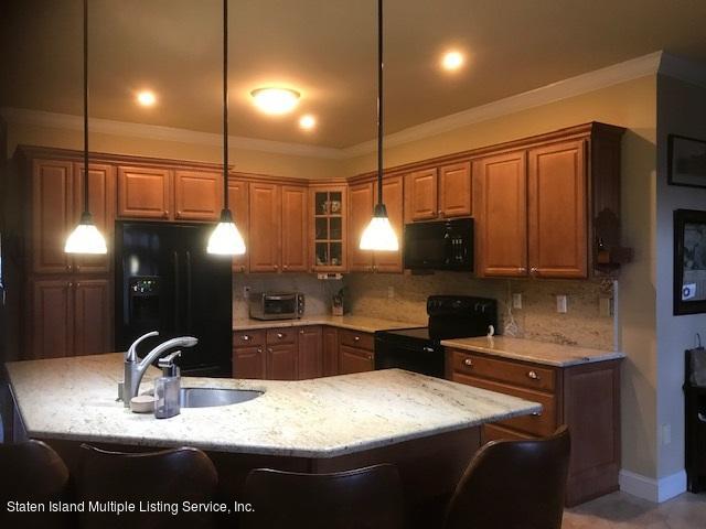26 Tides Lane Staten Island, NY 10309 - Photo 10 of 41 a kitchen with kitchen island granite countertop a sink a counter top space a stove and cabinets