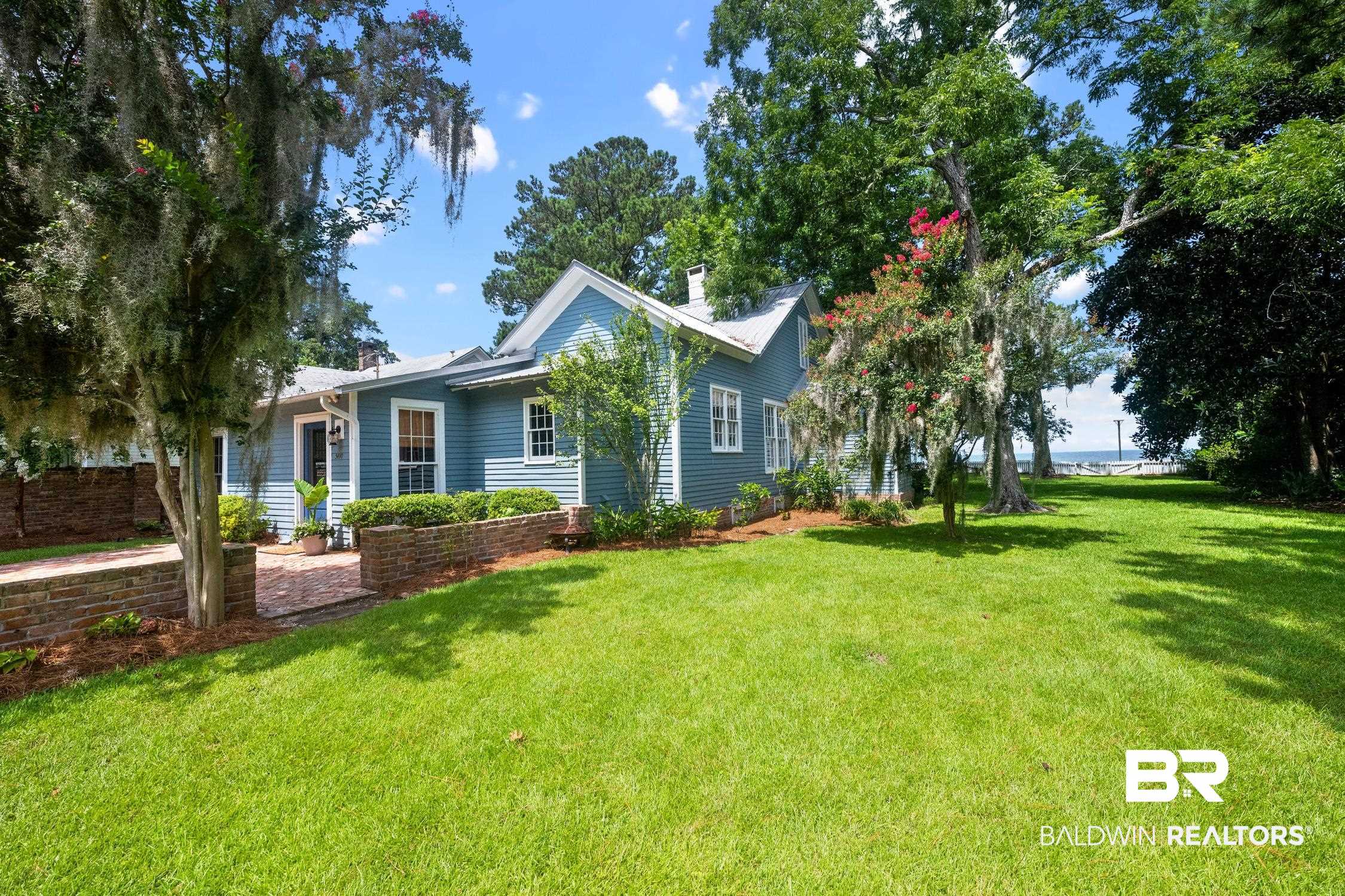 5490 Battles Road Fairhope, AL 36532 - Photo 1 of 47 Expansive green lawn bordering a light blue exterior residence with white trim