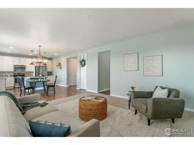 a living room with furniture and a view of kitchen