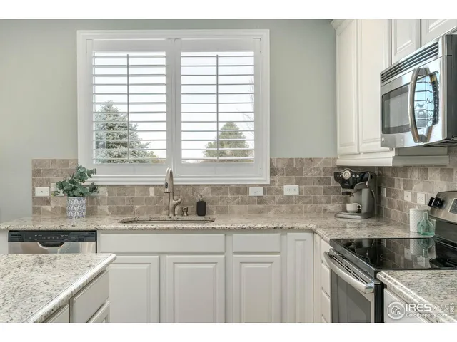 a kitchen with stainless steel appliances granite countertop a sink a stove and cabinets