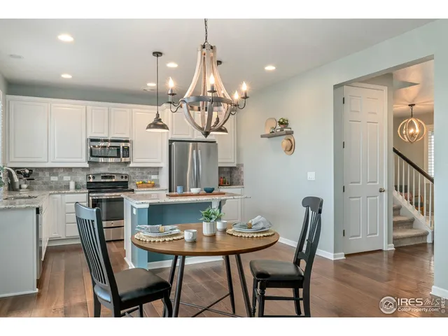a view of a dining room with furniture a chandelier and wooden floor