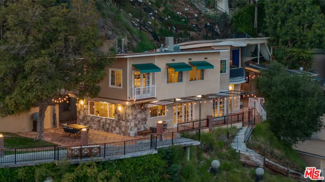 an aerial view of a house with swimming pool and garden