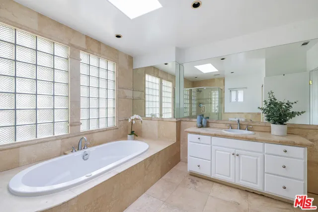 a bathroom with a granite countertop sink and a bathtub