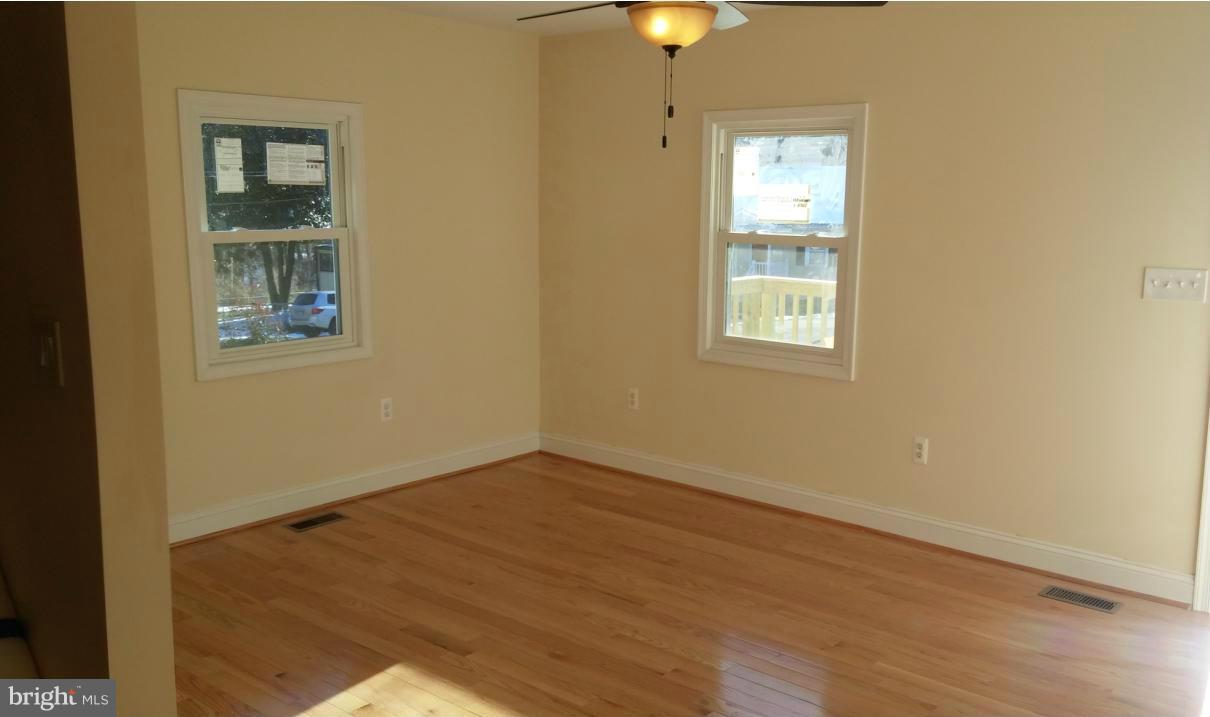 11405 Idlewood Road Silver Spring, MD 20906 - Photo 8 of 28 an empty room with a window and wooden floor