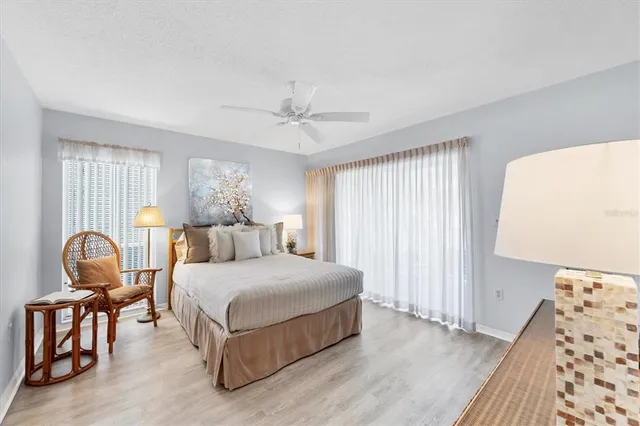 a bedroom with a bed chairs and white walls