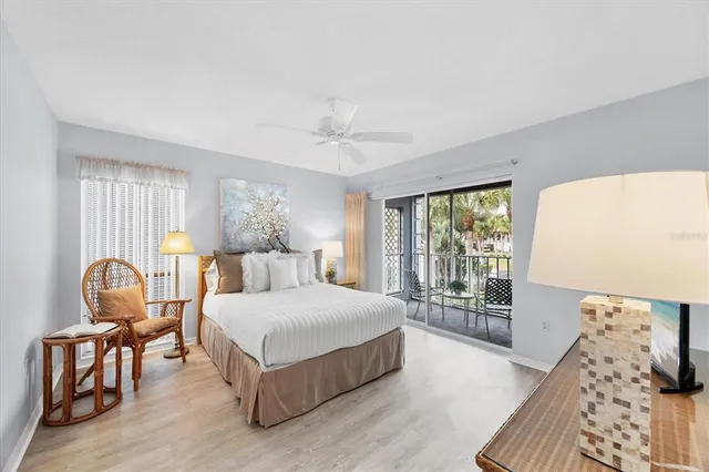 a bedroom with a bed chairs and wooden floor