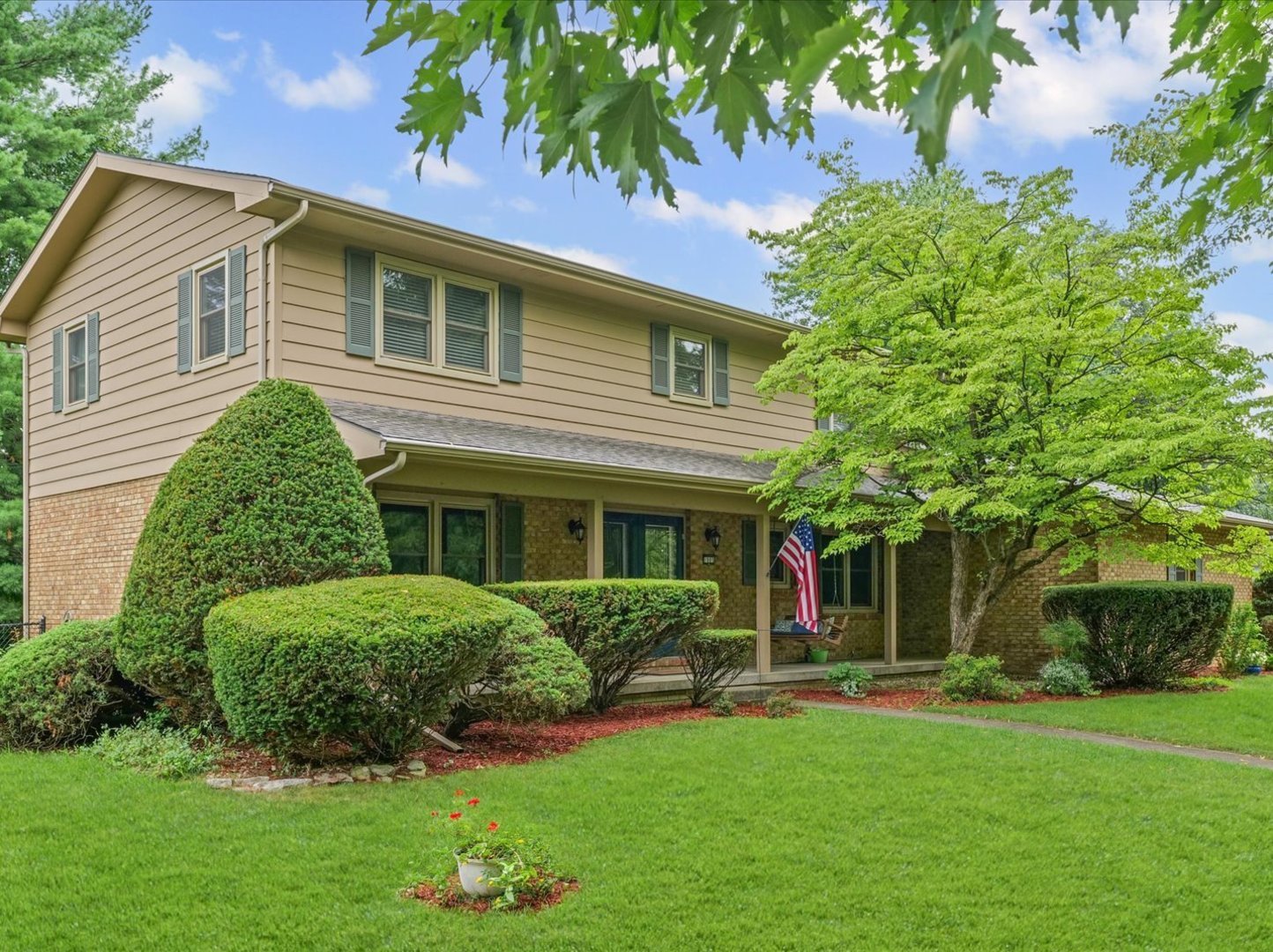 a front view of a house with a garden and plants