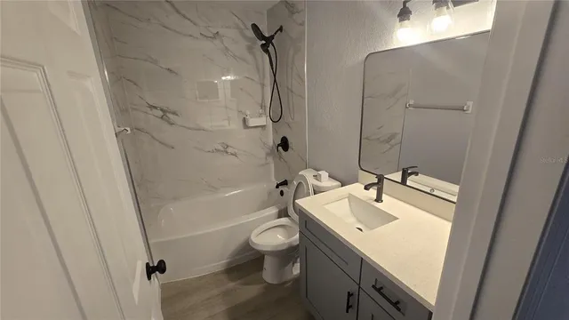 a kitchen with stainless steel appliances granite countertop a refrigerator a stove and a sink with wooden floor