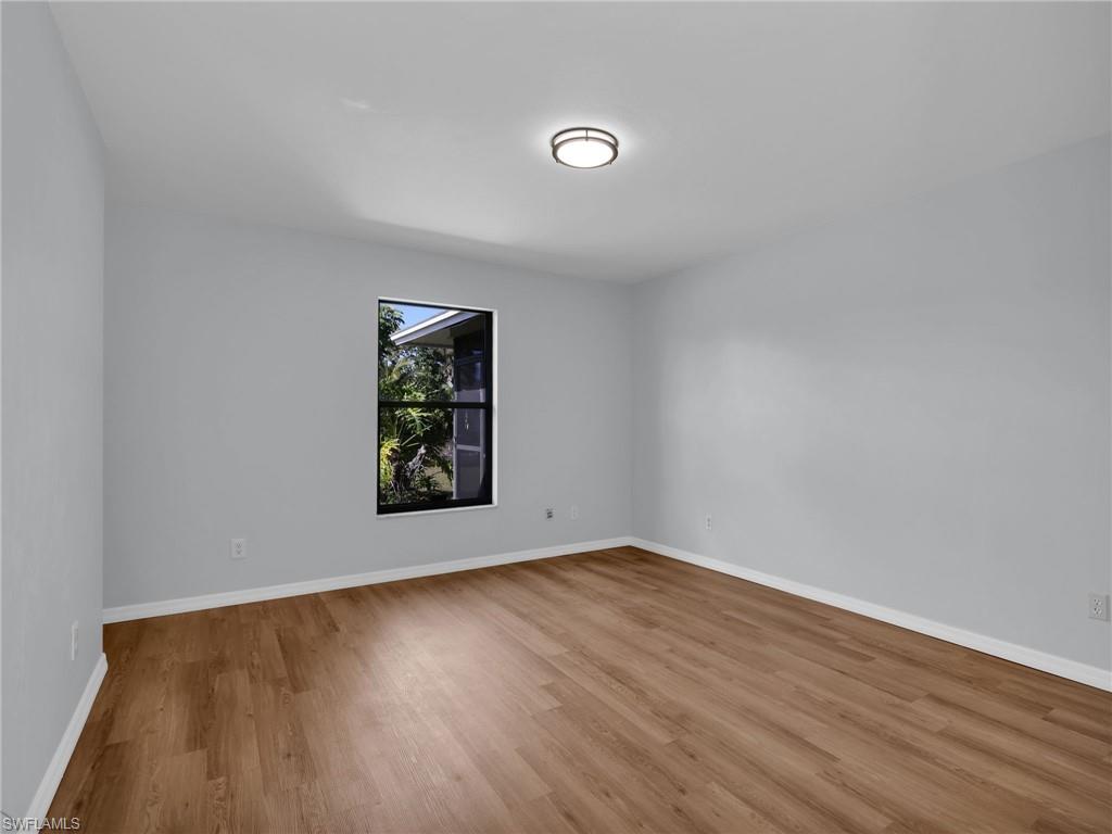 4991 18th Court Southwest Naples, FL 34116 - Photo 16 of 36 a view of an empty room with wooden floor and a window
