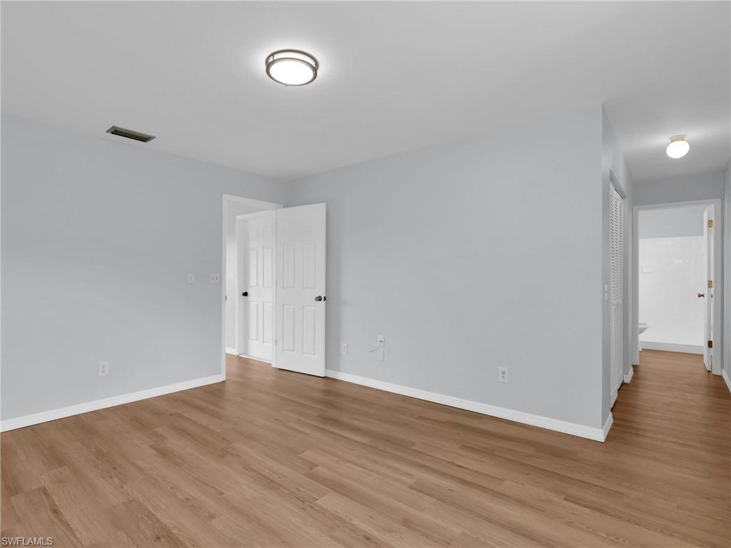 4991 18th Court Southwest Naples, FL 34116 - Photo 5 of 36 a view of an empty room with wooden floor
