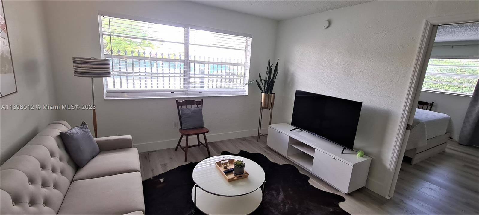 444 Southwest 4th Street, Unit 102 Miami, FL 33130 - Photo 3 of 11 a living room with furniture and a flat screen tv