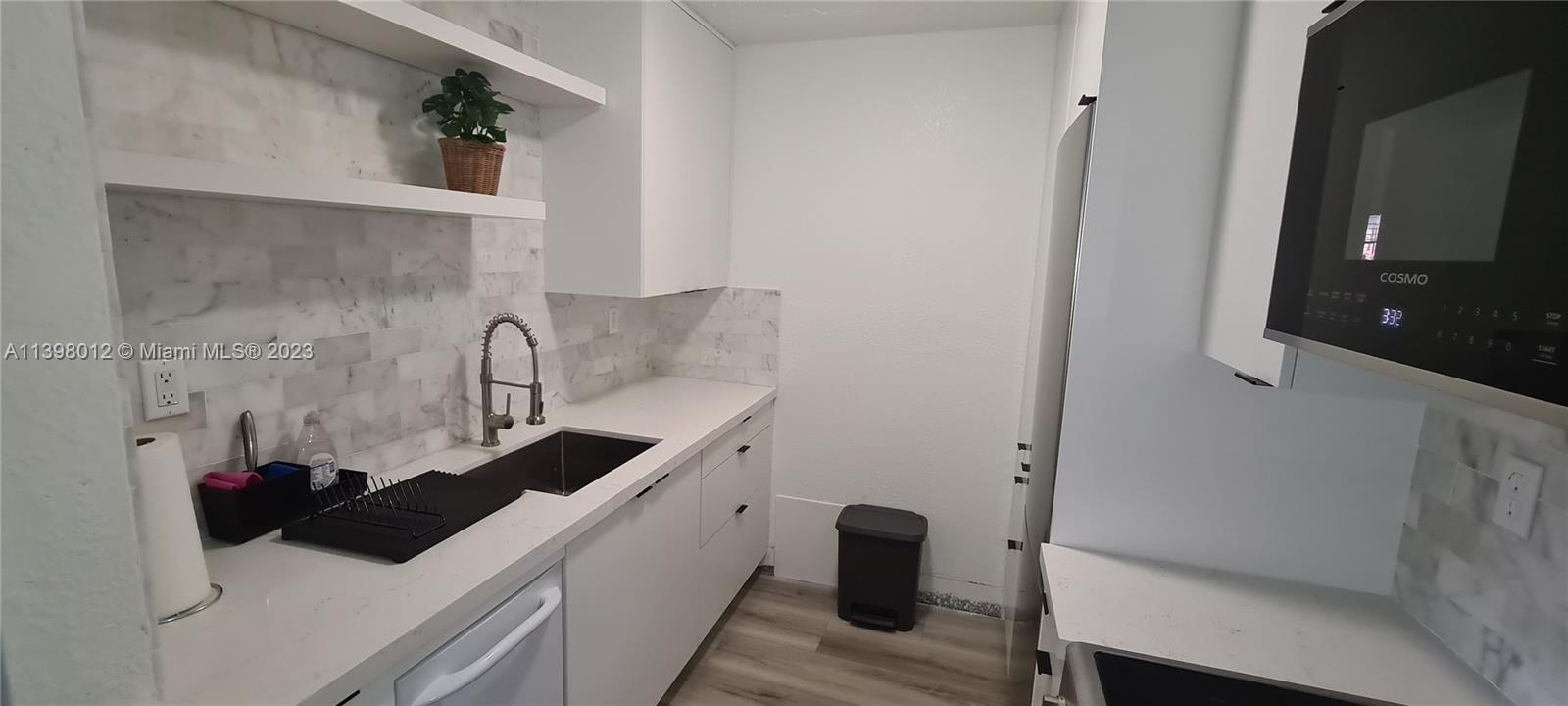 444 Southwest 4th Street, Unit 102 Miami, FL 33130 - Photo 6 of 11 a kitchen with a sink and a refrigerator