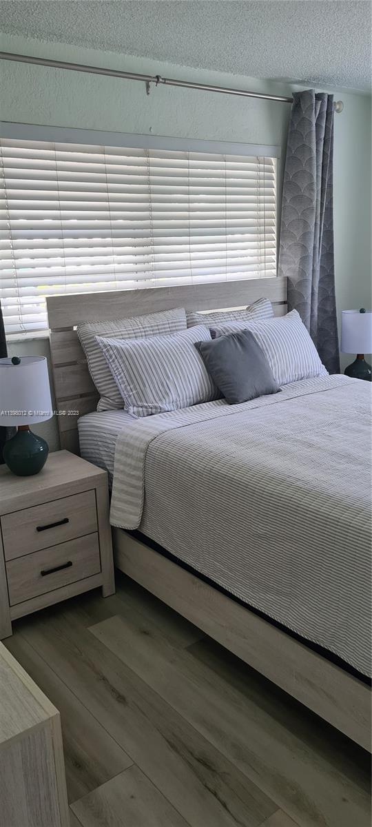 444 Southwest 4th Street, Unit 102 Miami, FL 33130 - Photo 8 of 11 a bedroom with a bed and a dresser