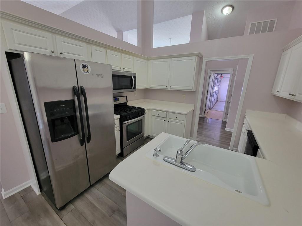 2213 Carlton Chase Road Dacula, GA 30019 - Photo 10 of 30 a kitchen with stainless steel appliances a refrigerator and a sink