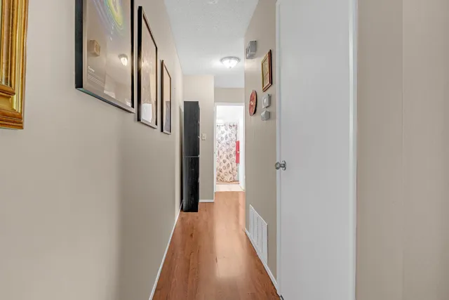 a view of a hallway with wooden floor
