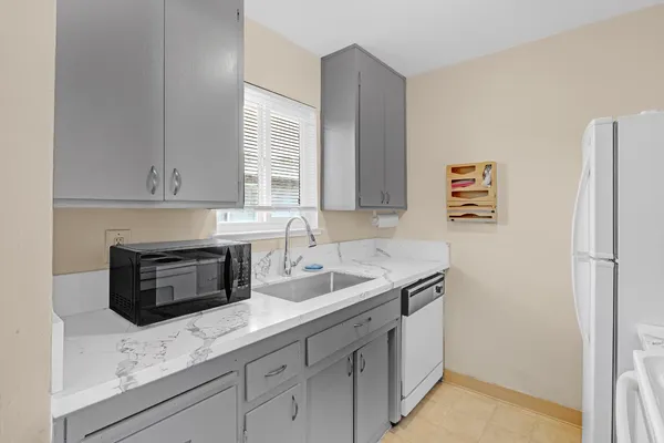 a kitchen with granite countertop a sink stove and refrigerator