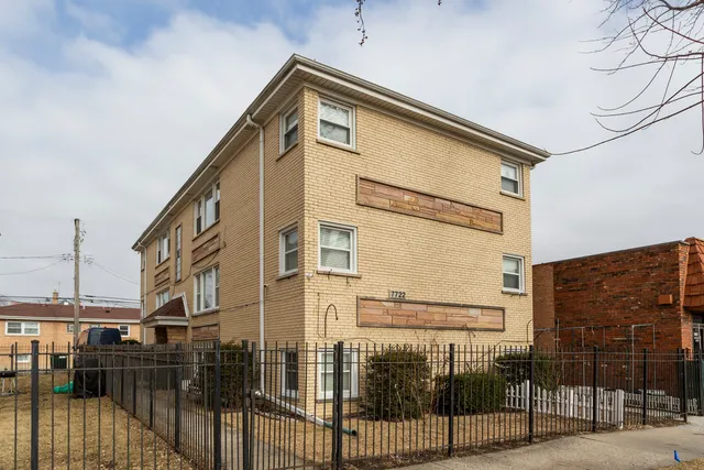 a front view of a house with iron fence