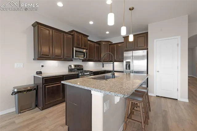 a kitchen with stainless steel appliances granite countertop a sink a stove and a refrigerator