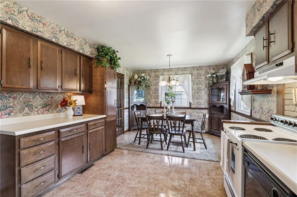 948 9th Street New Castle, PA 16101 - Photo 10 of 31 a open kitchen with stainless steel appliances granite countertop a stove top oven a sink dishwasher a dining table and chairs with wooden floor