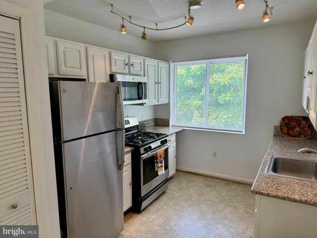a kitchen with stainless steel appliances a refrigerator sink and stove