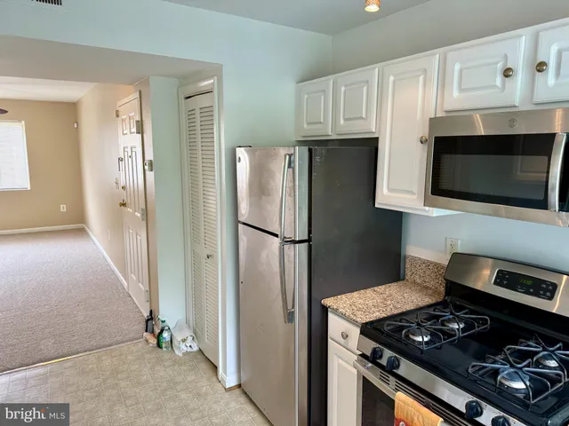 a kitchen with stainless steel appliances granite countertop a refrigerator stove and microwave