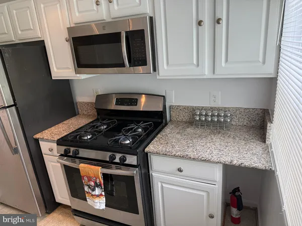 a kitchen with stainless steel appliances granite countertop a stove and a microwave