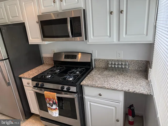 a kitchen with stainless steel appliances granite countertop a stove and a microwave