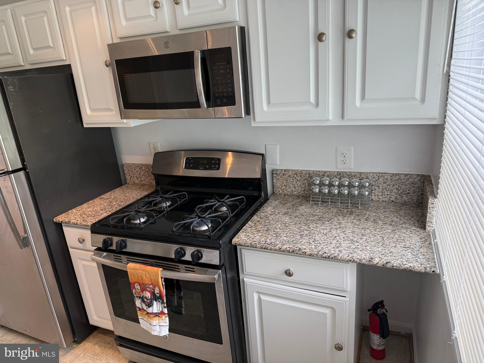 4212 Benning Road Northeast, Unit 6 Washington, DC 20019 - Photo 10 of 21 a kitchen with stainless steel appliances granite countertop a stove and a microwave